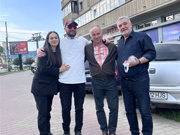 Alături de un client, &icirc;n fața casei sale